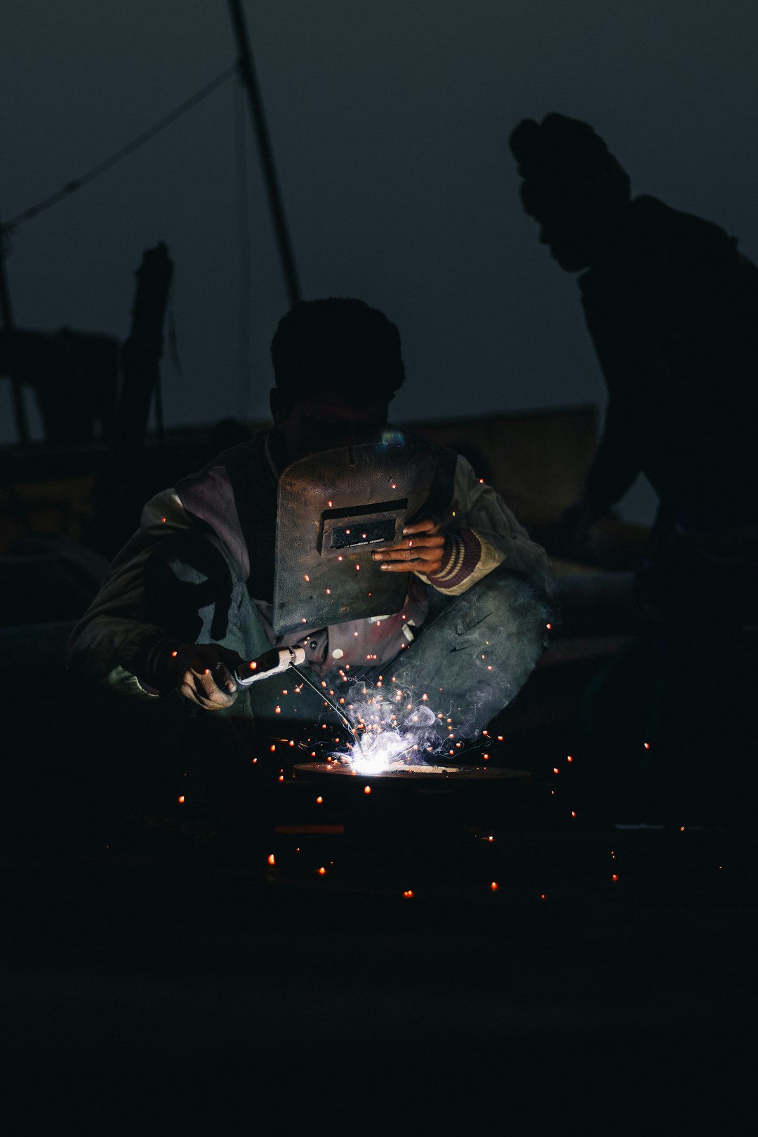 welders-working-on-a-piece-of-metal-in-the-dark-ozd1ympfwxe